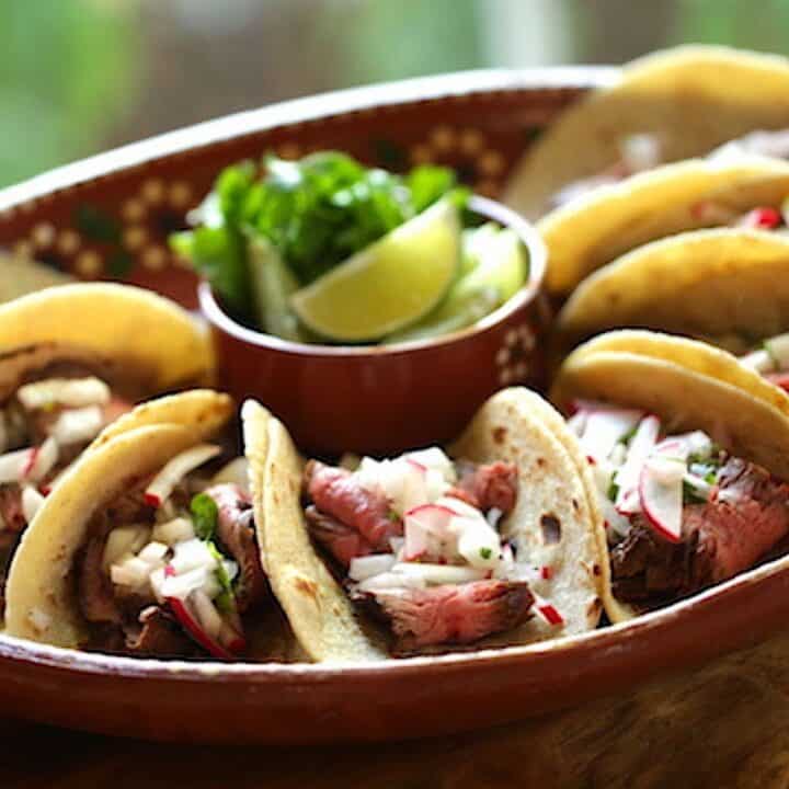 Carne Asada Tacos on a terra cotta platter