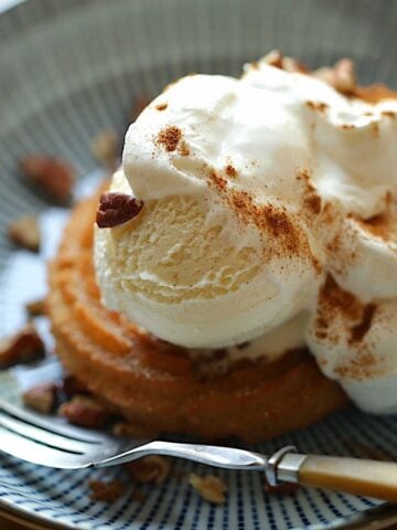 Churro Sundae on a blue plate with whipped cream, nuts and cinnamon