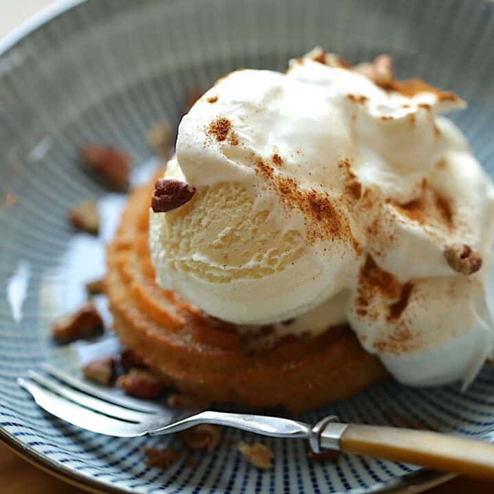 Churro Sundae on a blue plate with whipped cream, nuts and cinnamon