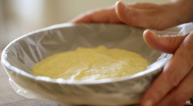 pastry cream with plastic wrap in a small bowl