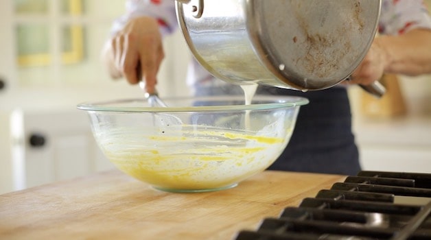 Whisking in hot milk into egg yolks for pastry cream