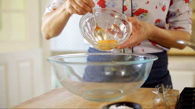 Adding egg yolks to a large mixing bowl