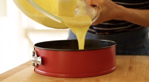 pouring key lime pie batter into a cheesecake pan 