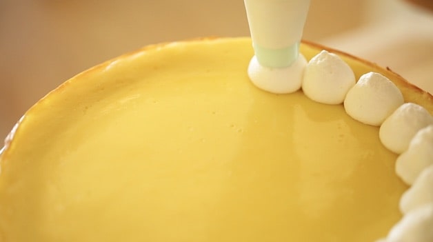 Tight shot of whipped cream mounds on a key lime cheesecake 