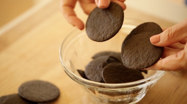 Chocolate Wafer Cookies in a bowl with hands holding them up