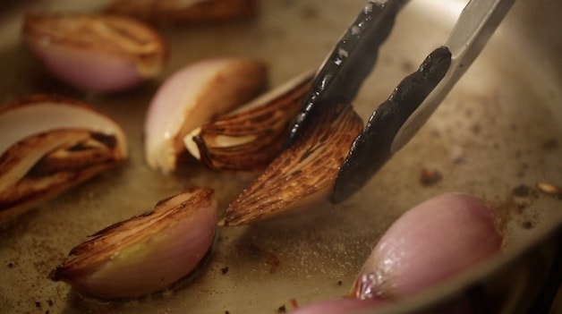 Shallots in a pan being caramelized