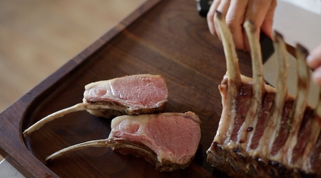 lamb chops sliced from rack and resting on a cutting board