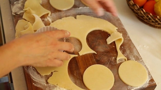 cutting out circles from pie dough on a cutting board