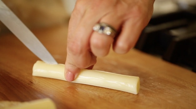 slicing a cheese stick with a knife