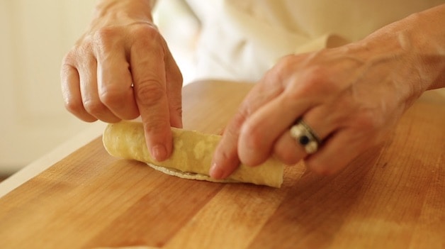 rolling up taquito on cutting board