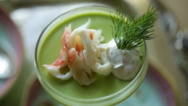 Top down view of a sweet pea panna cotta in a champagne coupe with king crab lemon dill cream and dill