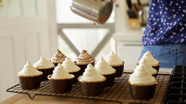 Shaking cocoa powder on Tiramisu cupcakes