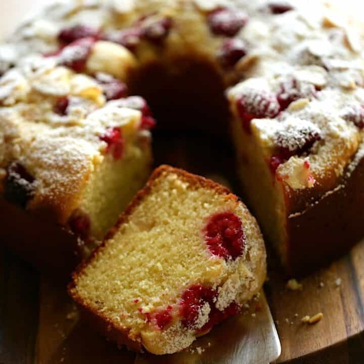 Raspberry Almond cake on a board with a slice taken out