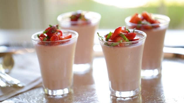 Cups of Strawberry Panna Cotta topped with strawberries on a tray