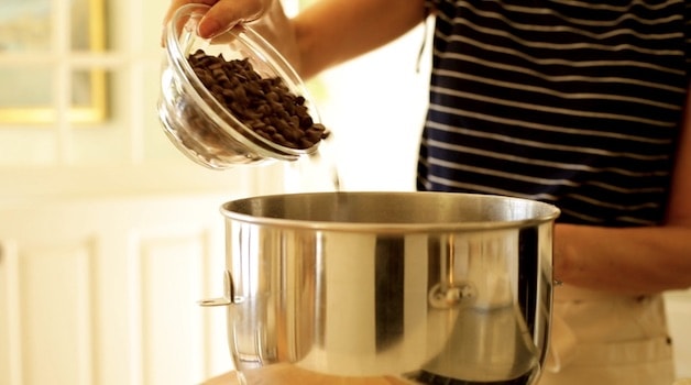 adding chocolate chips to a stand mixer