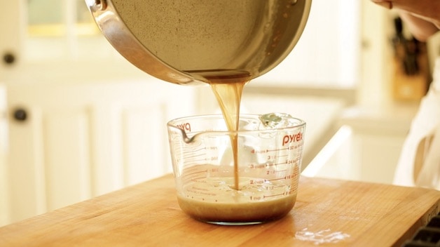 Pouring brown butter into a pyrex pitcher