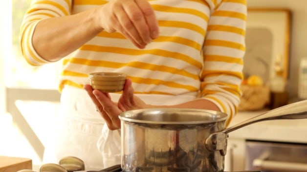 Sprinkling basil into pot