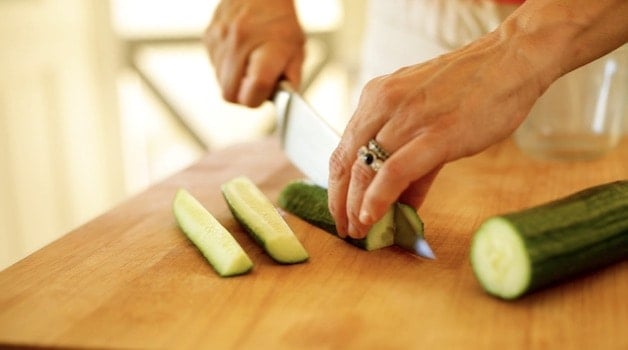 Slicing an English cucumber on a cutting board