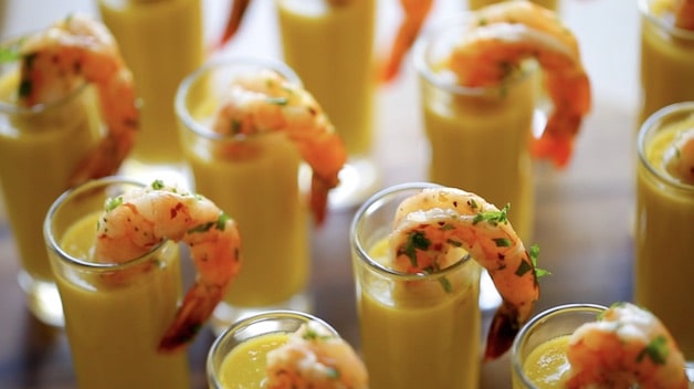 Yellow Gazpacho Soup with Shrimp Tails in shot glasses