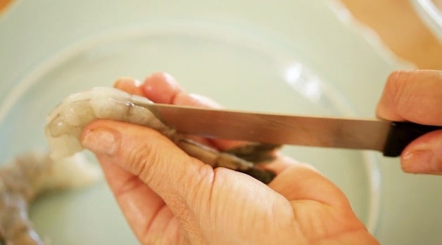 Cleaning raw shrimp with a knife