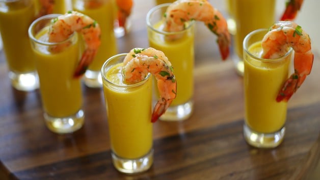 Yellow Gazpacho soup in shot glasses with shrimp