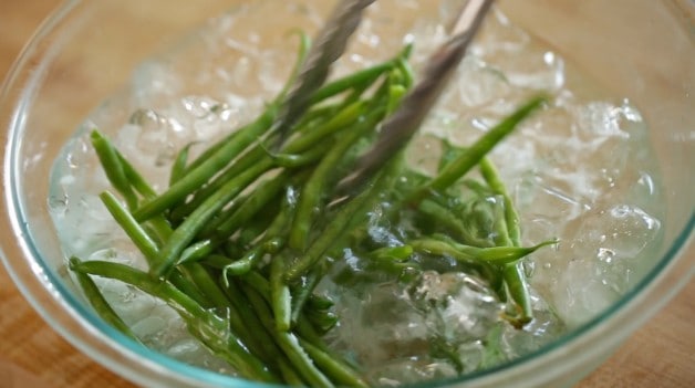 Blanching cooked green beans in ice water