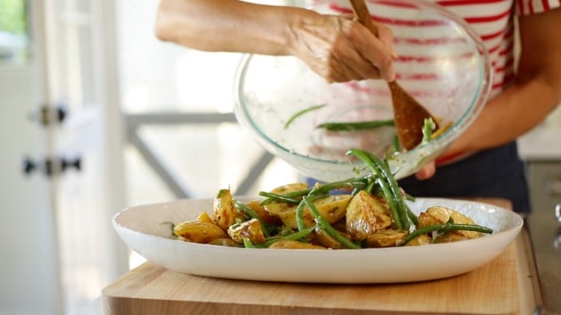 Transferring potato salad from a bowl to a platter