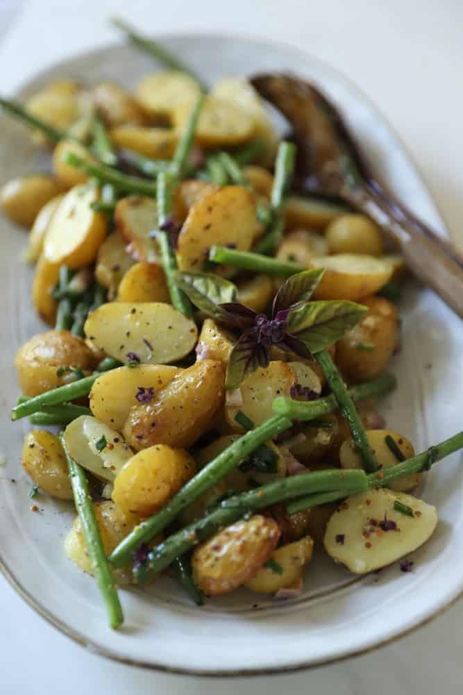 A No-Mayo potato salad on a platter with green beans.