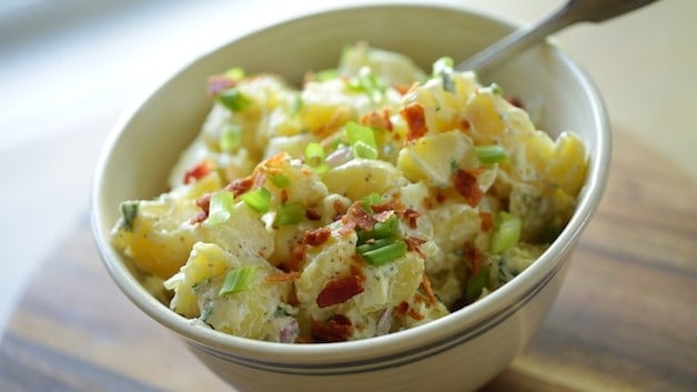 Close up of Traditional Potato Salad garnished with bacon and green onion