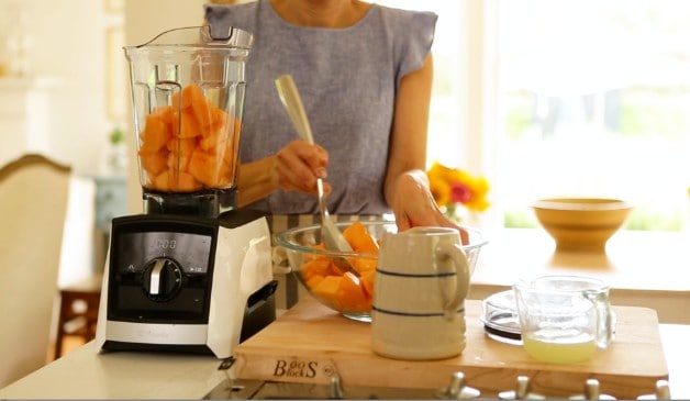 Putting chopped cantaloupe in blender