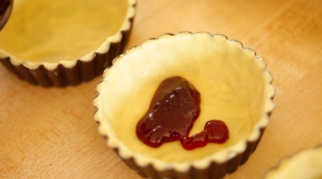 Confiture de cerises dans la pâte à tarte pour la recette de tarte aux cerises Bakewell