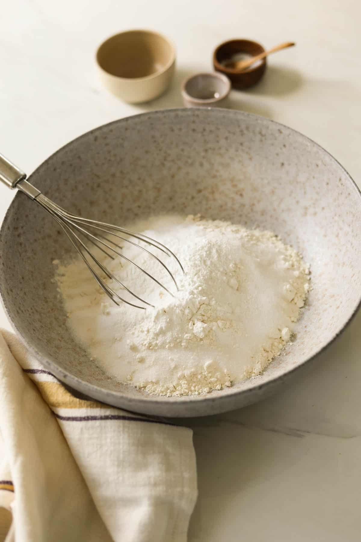 Dry ingredients in a bowl with a whisk.