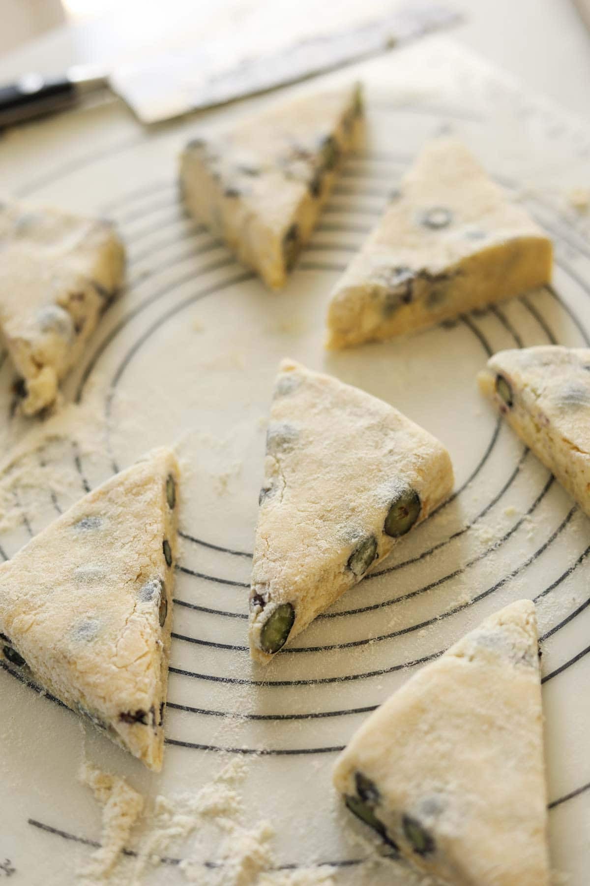 Scones cut into triangles on a rolling mat.
