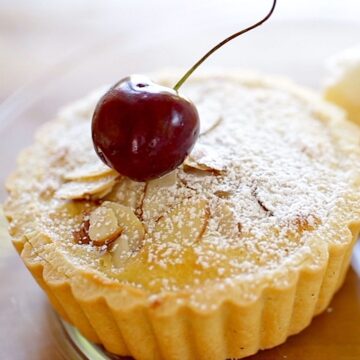 Cherry Bakewell Tart on a plate with cherry garnish