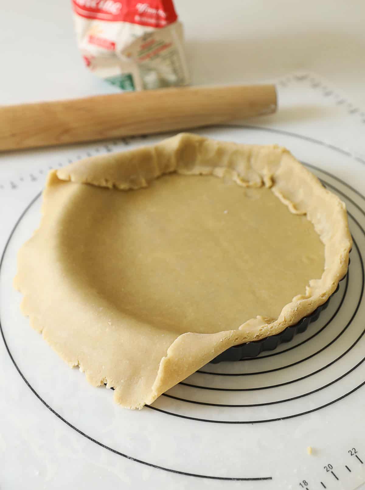 Pastry dough fitted into a fluted tart tin.