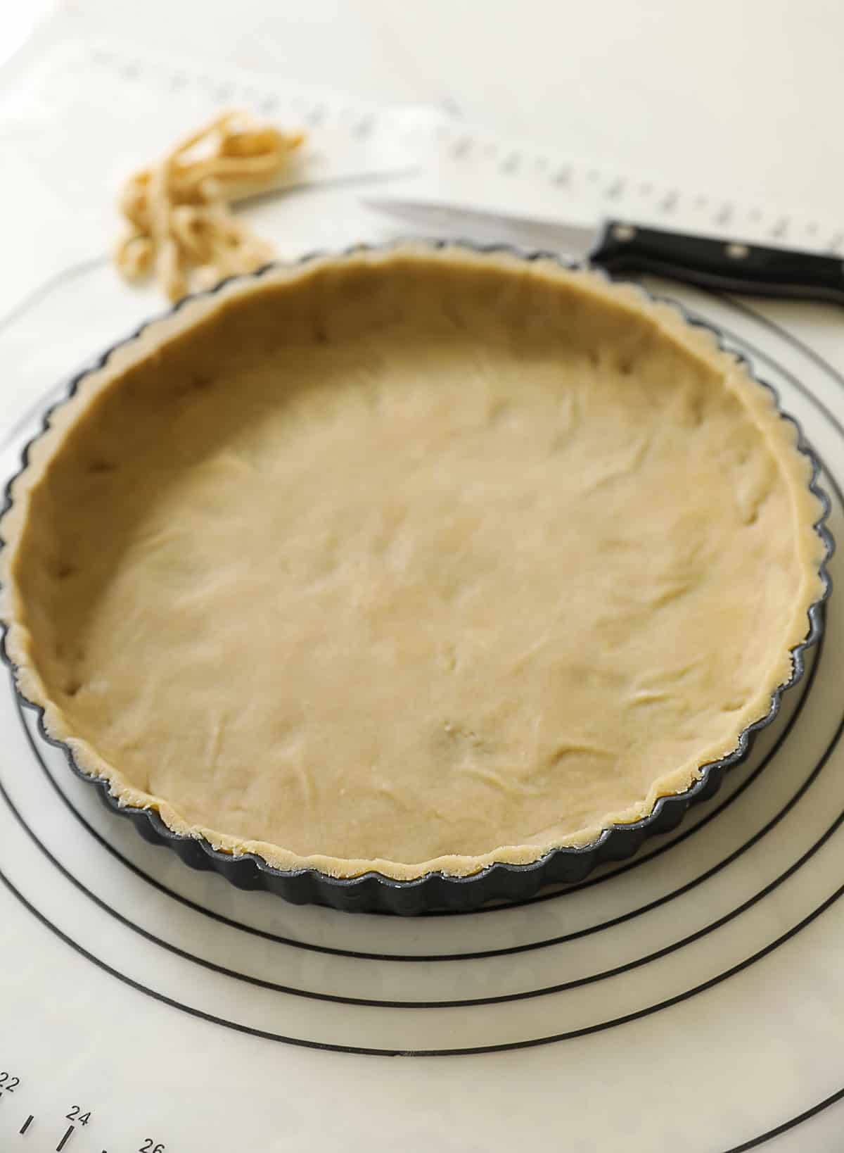 a tart tin trimmed with pastry dough.