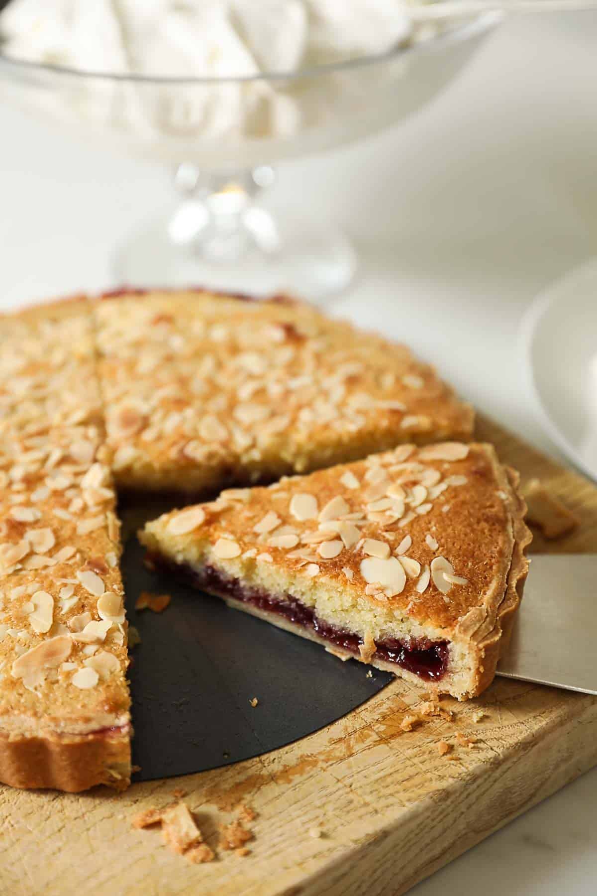 a slice of cherry bakewell tart, showing the cherry jam interior.