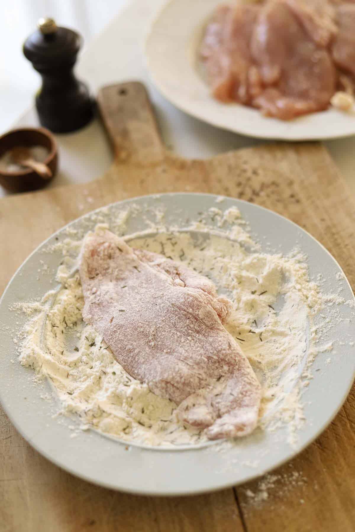 pounded chicken breast dredging in flour.