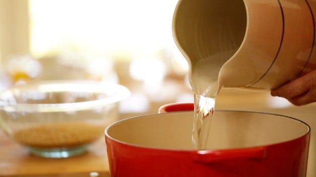 Pouring water into large pot on stove