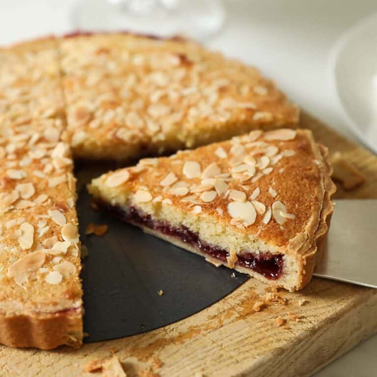 a slice of cherry bakewell tart showing cherry jam.