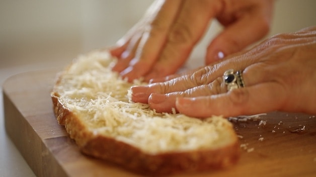 pressing cheese into a slice of sourdough bread