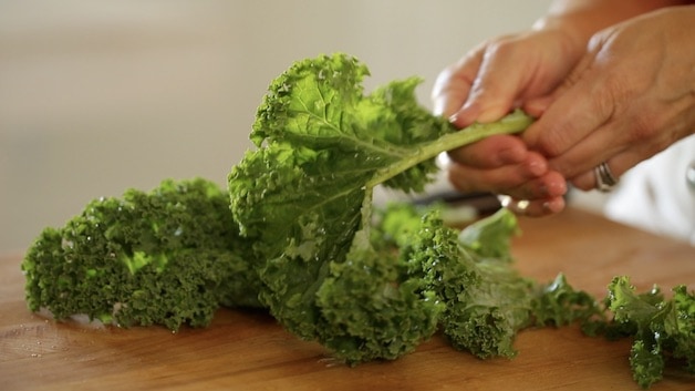 stripping kale leaves from its stalks