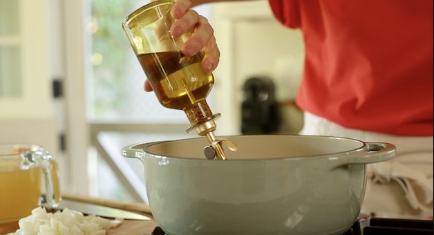 adding olive oil to a dutch oven