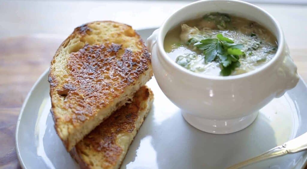 white bean soup in a bowl with grilled cheese sandwiches