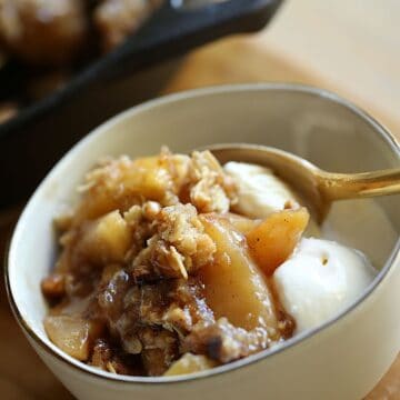 Apple Crisp with Vanilla Ice Cream in a bowl with a gold spoon