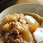 Tight Shot of Apple Crisp in a small bowl with Ice Cream