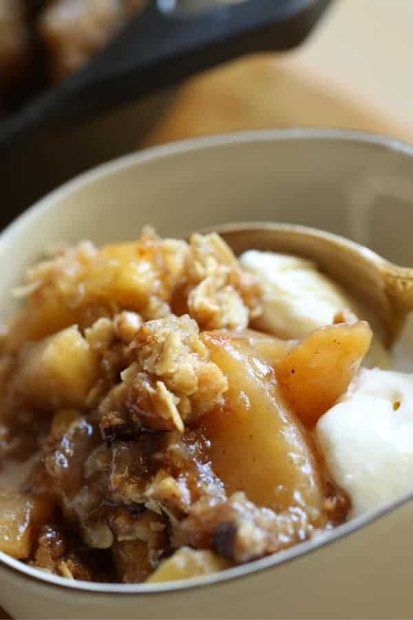 Tight Shot of Apple Crisp in a small bowl with Ice Cream