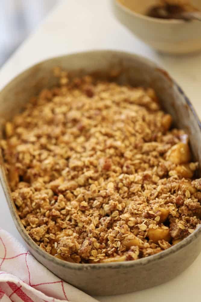 Apples covered with oatmeal topping reading for the oven.