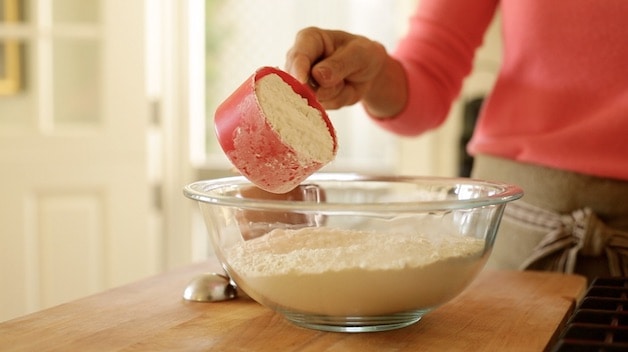 adding flour to bowl