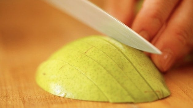 slicing pears on a cutting board into thin slices